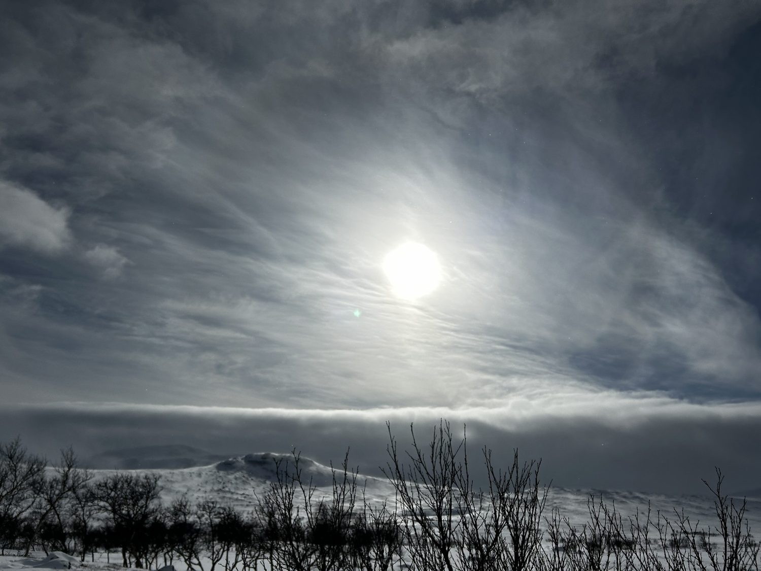 Winter sun over mountains and dramatic clouds